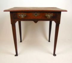 An 18th century oak single drawer freestanding table, the moulded top over shaped aprons on turned