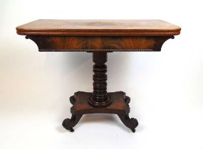 An early 19th century mahogany tea table, the fold over top supported on a swivel action on a turned