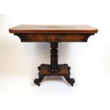 An early 19th century mahogany tea table, the fold over top supported on a swivel action on a turned