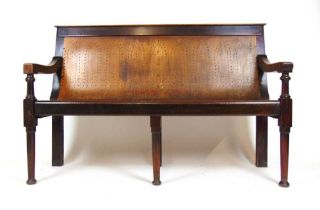 An early 20th century beech and plywood club bench, the ply seat with gothic arch pierced decoration
