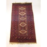 A handwoven Afghan rug, the multi line border enclosing the cream ground field with five central
