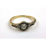 An early 20th century yellow metal and diamond ring, the central old cut stone flanked by two