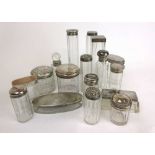 A collection of silver topped bottles and dressing table pots. Various hallmarks.