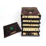 An early 20th century Chinese bone and bamboo mahjong set in a padouk and brass mounted box