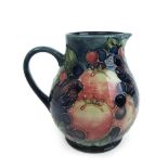 A Moorcroft Berry pattern jug decorated on a blue ground, h. 14.5 cm