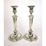 A pair of Elizabeth II silver tapering candlesticks with beaded decoration. Presentation