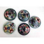 A collection of five Moorcroft pot lids to include Orchid pattern, dia. 14.5 cm