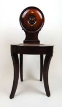 A Victorian mahogany hall chair, the circular turned back over the dish seat on reeded sabre legs,