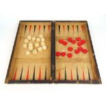 A 19th century set of turned bone draughts/backgammon pieces in a faux book embossed leather case