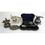 A collection of silver and white metal items to include a sauce boat, cream jug, cased egg and spoon
