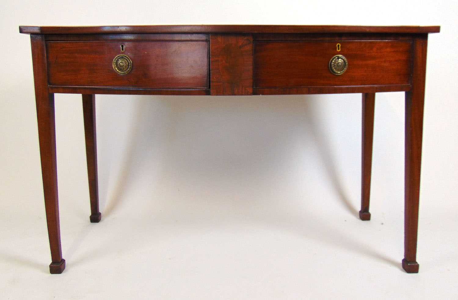 An early 19th century mahogany and rosewood banded bow front sideboard, the top over two drawers