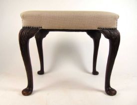 An early 20th century, 18th century style walnut stool upholstered in a white gold fabric, the
