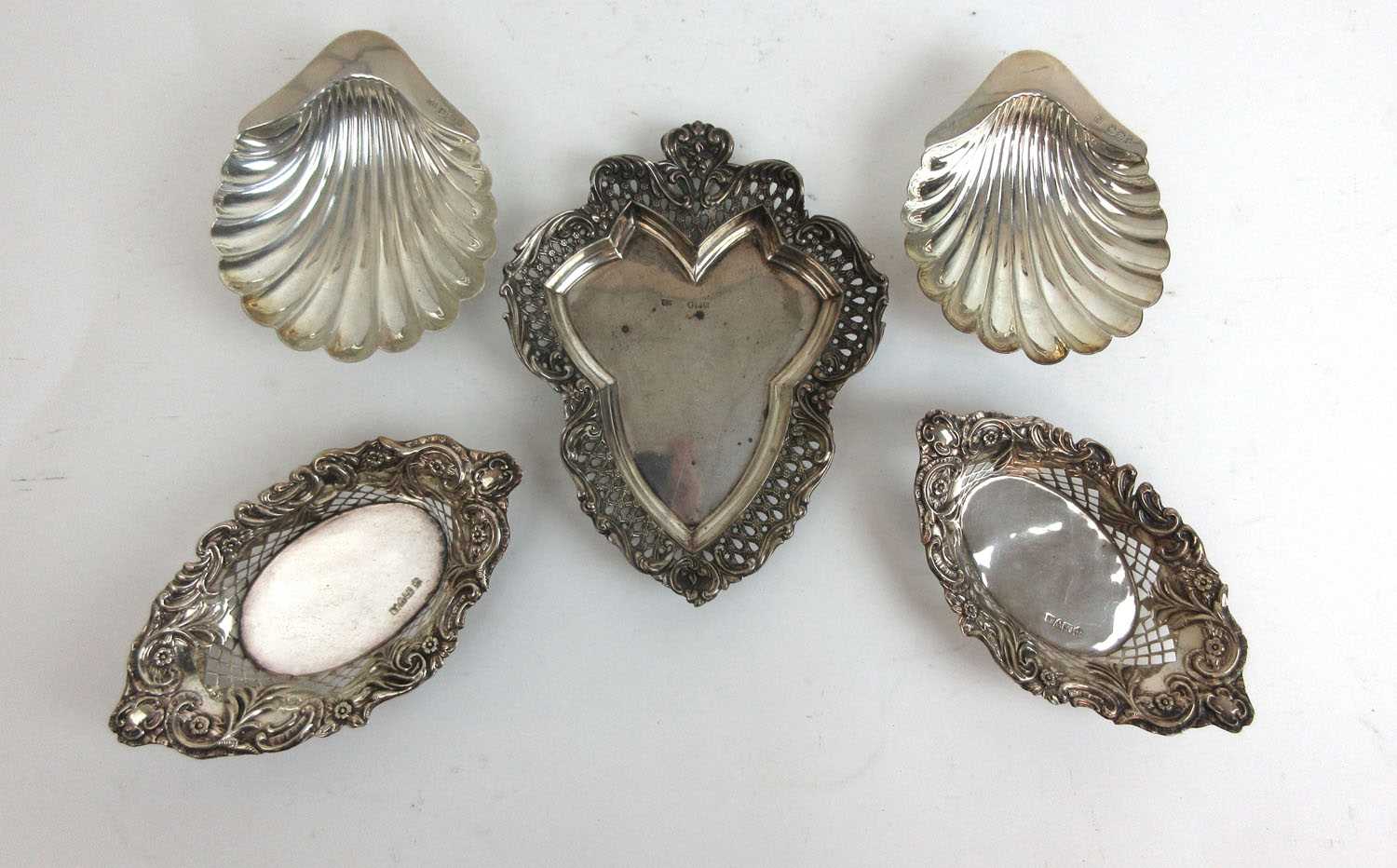 A pair of Victorian silver pierced bon-bon dishes together with a pair of scallop butter dishes