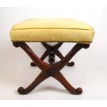 An early 19th century mahogany X-framed stool upholstered in a yellow silk, h. 43 cm, w. 43 cm, d.