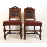 A pair of Victorian oak side chairs upholstered in red leather, the back panel carved with the