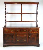 An 18th century oak dresser, the plate rack over the base with drawers and cupboard doors on bracket