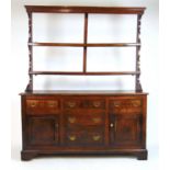 An 18th century oak dresser, the plate rack over the base with drawers and cupboard doors on bracket