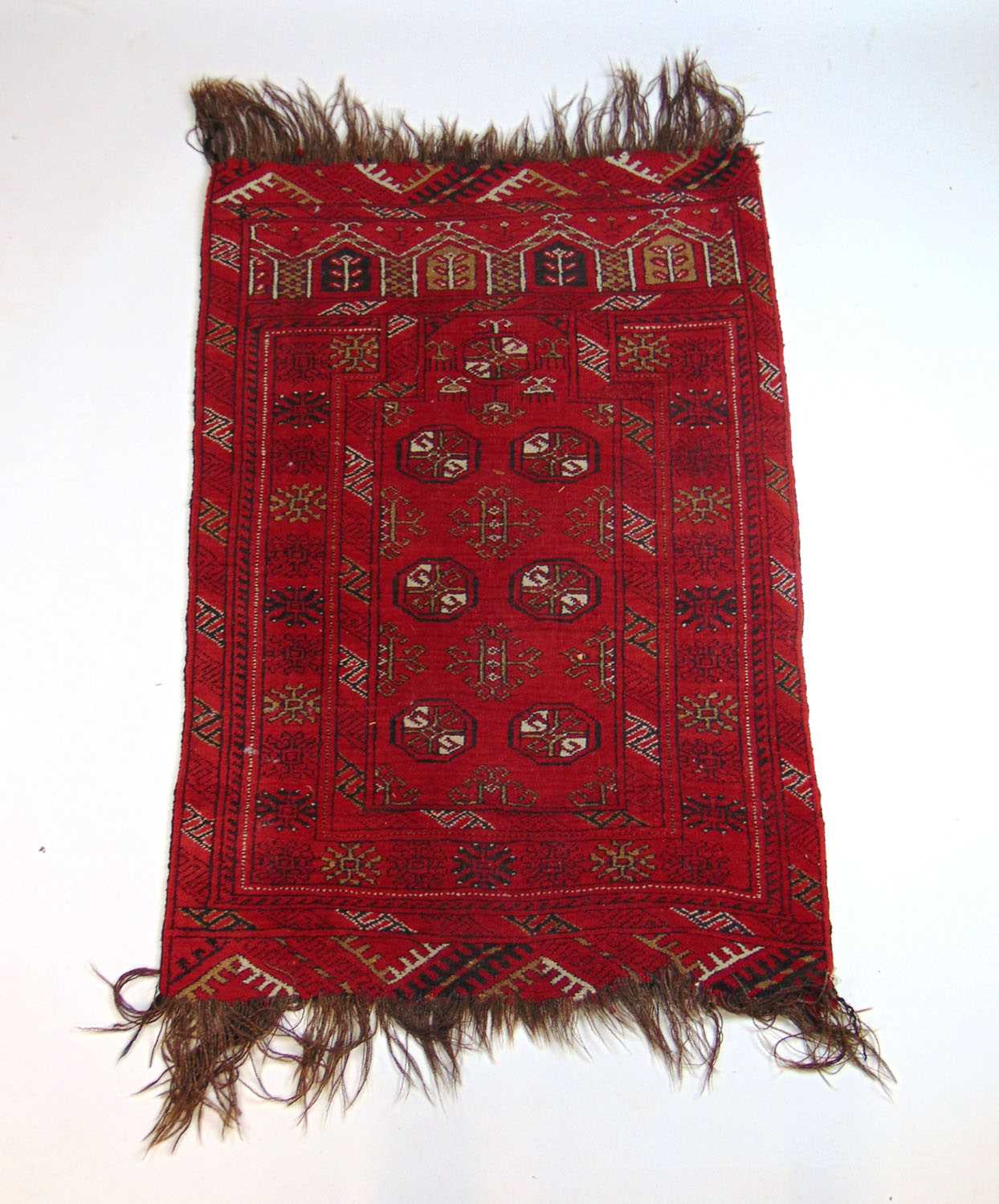 A handwoven Afghan prayer rug, the multi line border surrounding the red ground field with six - Bild 2 aus 2