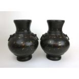 A pair of Chinese Han style bronze baluster vases having yellow and white metal inlay and ring