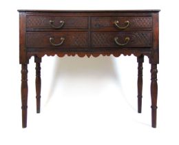 An early 20th century oak side table, the moulded top over four carved drawers on turned legs, h. 75