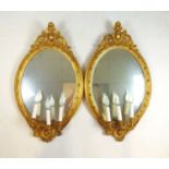 A pair of 19th century French giltwood mirrors, the frames with scrolling foliate decoration