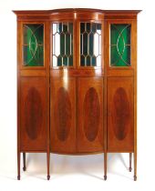 An Edwardian mahogany boxwood strung and tulipwood banded bow front side cabinet, The cornice over