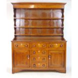 An 18th century oak dresser, the plate rack over the base with three drawers over two cupboard doors