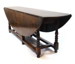 A 20th century, 18th century style oak dining/wake table, the drop leaf top supported on single gate
