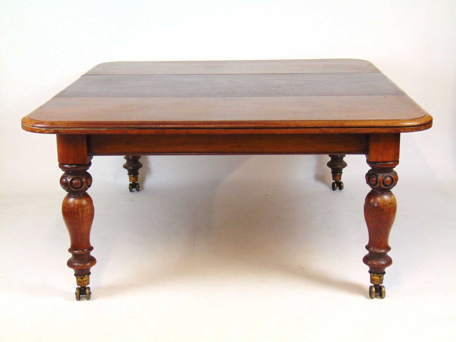 A Victorian mahogany extending dining table, the moulded top on pull-out mechanism with three leaf's