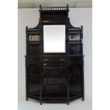 A late Victorian aesthetic movement ebonized display cabinet, the back with beveled mirrors and