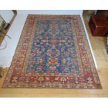A handwoven Turkish rug, the multi line border surrounding a blue ground field with floral motif's