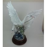 A large Lladro figure group of two swans in flight. On plinth base, h. 68 cmChip to top swans