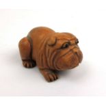 A 19th century Japanese carved wooden netsuke in the form of a pug. Signed to belly, l. 6 cm