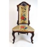 A Victorian walnut nursing chair upholstered in a floral needle work fabric, h. 109 cm, w. 54 cm, d.