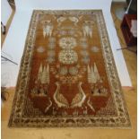 A handwoven Oriental rug, the triple line border surrounding a brown ground field with bird and tree