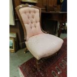 An Edwardian walnut boxwood strung and marquetry nursing chair upholstered in a floral pink