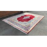 A large handwoven Persian rug, the multi line border surrounding a red ground field with central