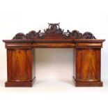 A Victorian mahogany twin pedestal reverse breakfront sideboard, the back with carved serpents and