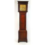 A late 18th century oak long case clock, the blind fret cornice over the engraved brass face with