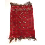 A handwoven Afghan prayer rug, the multi line border surrounding the red ground field with six