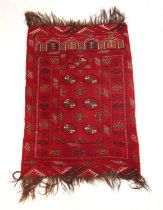 A handwoven Afghan prayer rug, the multi line border surrounding the red ground field with six