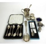 An assortment of silver and white metal items to include cup, salts, spoons, napkin rings etc.