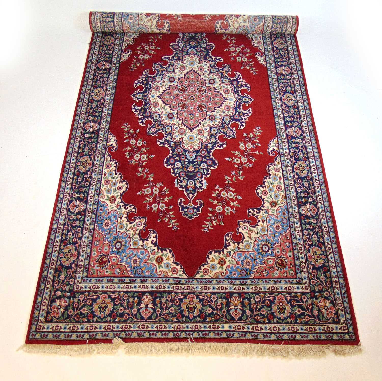 A handwoven Persian rug, the multi line border surrounding a red ground field with three - Bild 2 aus 2