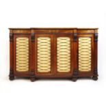 A Regency rosewood and brass inlaid breakfront sideboard, the top over four door with pleated silk