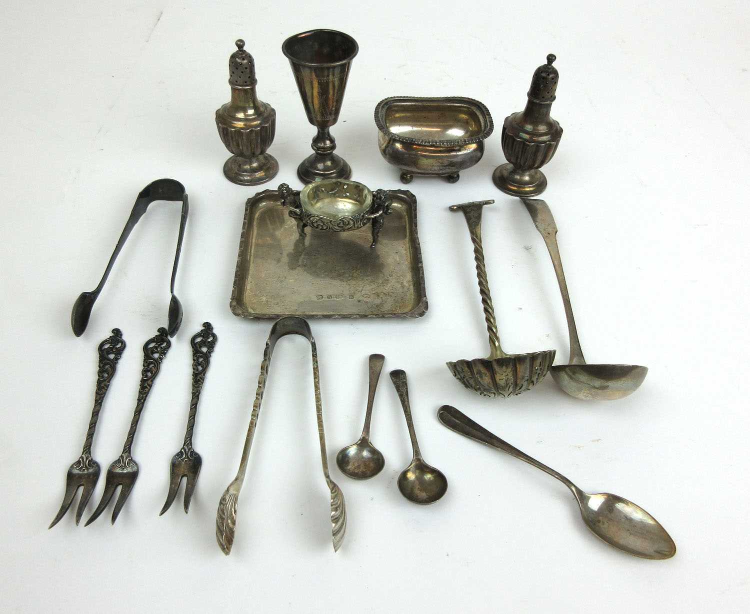 A collection of silver and white metal items to include pepper pots, dish, open salts, cup etc.