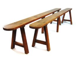 A pair of 19th century French cherrywood benches, the seat over trestle end supports and a central
