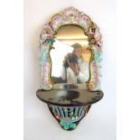 A 19th century Meissen style porcelain wall mirror having encrusted floral and putti decoration