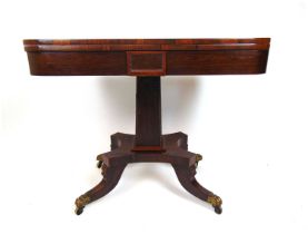A regency rosewood tea table, the fold over top supported on a swivel action over the tapering