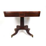 A regency rosewood tea table, the fold over top supported on a swivel action over the tapering