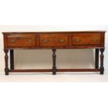 An early 18th century oak dresser base, the top over three drawers on turned legs, h. 78 cm, w.